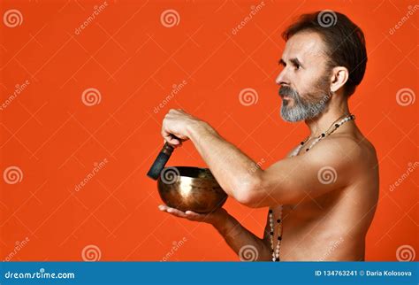 Elderly Yogi Male With Naked Torso In Brown Pants Is Practicing Yoga Lying On The Floor