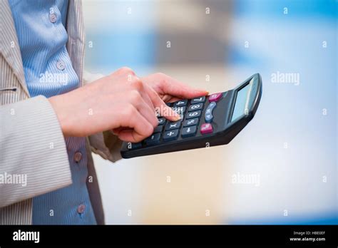 Hands calculating profit on the calculator Stock Photo - Alamy
