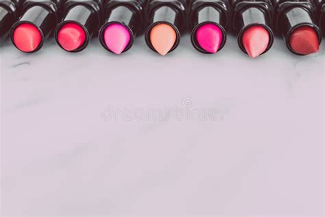 Group Of Red Pink And Nude Lipsticks With Different Colors And Textures Lined Up Lying On Marble