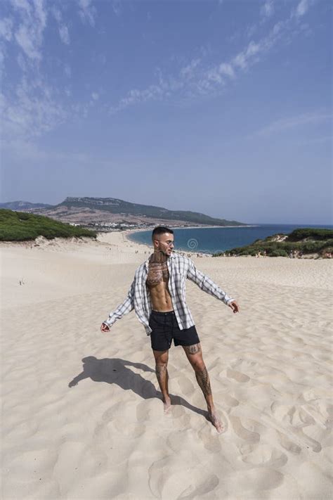 Handsome Half Naked Caucasian Man Walking On The Sand Enjoying His Vacation Stock Image