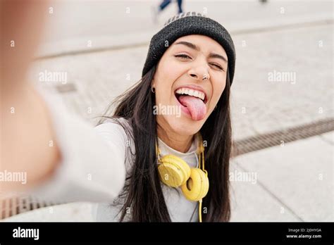 Latina Taking A Selfie With Her Smart Phone Sticking Out Her Tongue And