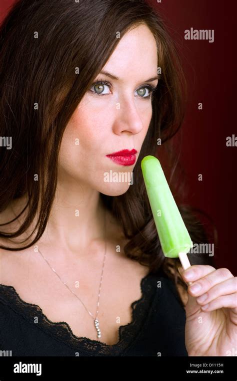 A Beautiful Brunette Has A Frozen Treat Looking Off Camera Stock Photo Alamy
