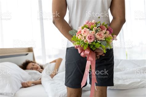 Young Man Hiding Bouquet Of Flower Behind His Back Before Surprise His