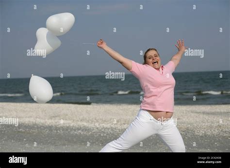 Blonde Chubby Woman Joyfully Holds Balloons In Her Hand Fun Leisure Beach Stock Photo Alamy