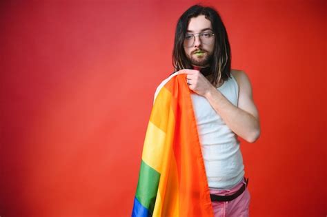 Hombre gay feliz divirtiéndose sosteniendo el símbolo de la bandera del arco iris de la