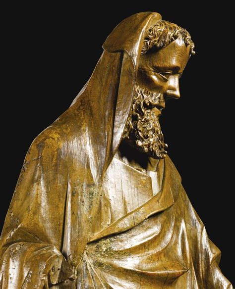 A Golden Statue Of A Man Wearing A Veil And Holding A Book In His Hands