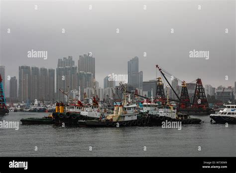 Tugboats And Container Barges With Derrick Cranes On A Foggy Day In Yau