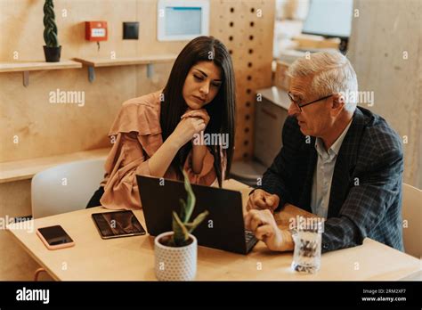Female Brunette Project Manager Listening Carefully To Her Senior Male Colleague Explaining