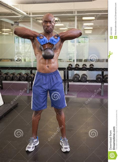 Sino De Levantamento Da Chaleira Do Homem Muscular No Gym Foto De Stock