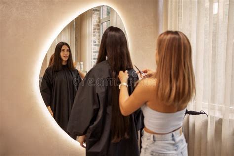 Blonde Friseur Schneidet Ihr Kunsthaar In Einem Salon Brunette Junge Frau Schaut In Einen