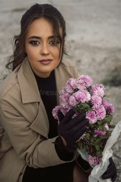 Brunette Girl In Beige Coat Sits On Chair Among Rocks Stock Image Image Of Hair Blue 355415691