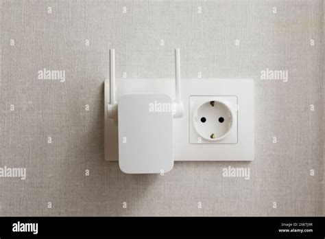 Wifi Range Extender Plugged Into Wall Outlet On Textured Background