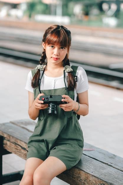 Premium Photo 亞洲年輕女子微笑遊客旅行者女孩行走和持有相機等待火車旅行旅行是在鐵路平台上拍攝的泰國夏天放鬆假期概念