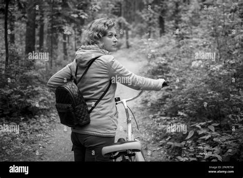 A Blonde Woman Walks Through The Forest With A Bicycle Black And Whait Photo Stock Photo Alamy