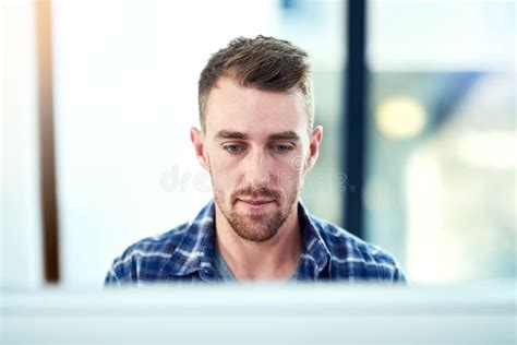 Putting The Work In A Young Man Working In His Office Stock Photo