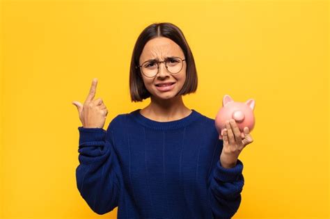 Joven mujer latina que se siente confundida y desconcertada mostrando que está loco loco o