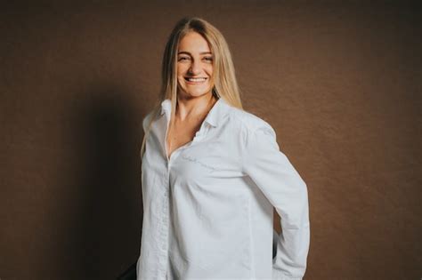 Free Photo Attractive Caucasian Blonde Female In A White Shirt Posing On A Brown Background