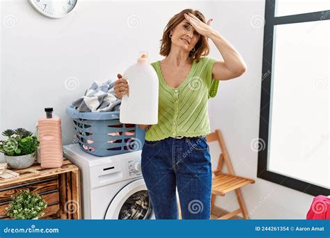 Mujer De Mediana Edad Lavando La Ropa Con Una Botella Detergente