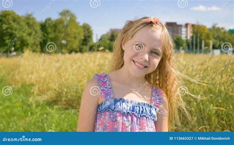 Portrait Of A Blonde And Smiling Russian Girl Next To The Field Stock