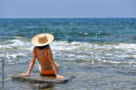 Sexy Bikini Tanning Woman Relaxing On The Beach With A Hat Stock Photo Adobe Stock