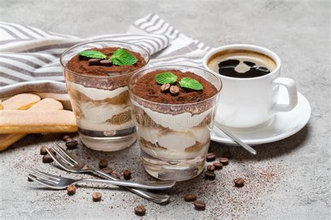 Dos Porciones Del Postre Cl Sico Del Tiramisu En Un Vidrio Y Una Taza