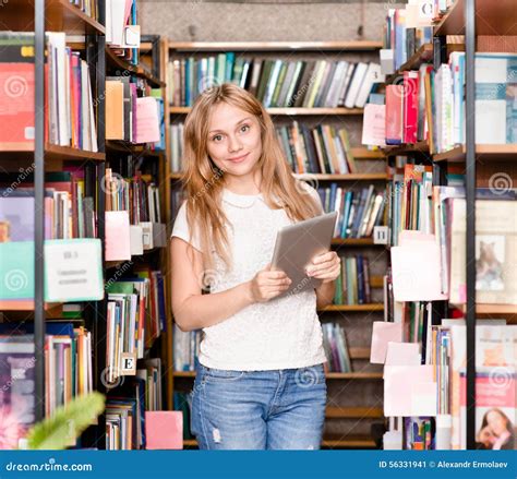 Счастливая девушка с планшетом в библиотеке Стоковое Изображение ...