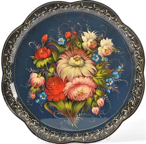 an ornate blue plate with flowers painted on the side and gold trimming ...