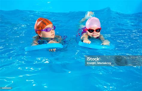 Dua Gadis Kecil Belajar Berenang Di Kolam Renang Menggunakan Papan