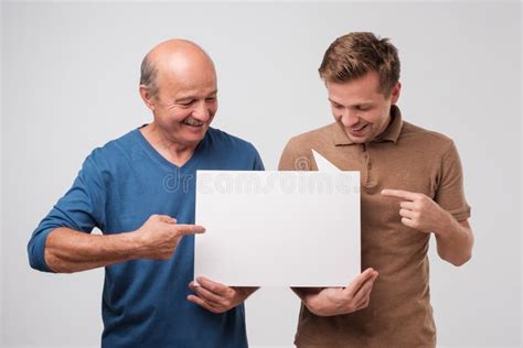 Two Mature Men Father And Son Are Holding A White Empty Billboard Together Stock Image Image