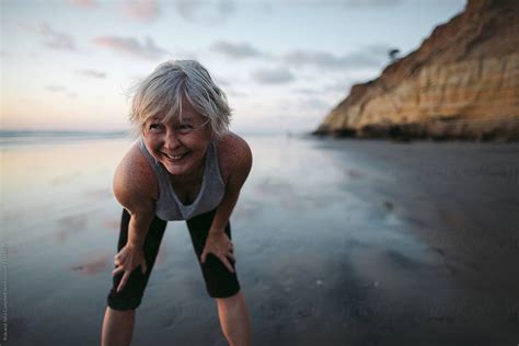 Vibrant Mature Woman Enjoying Herself On The Beach At Sunset By Stocksy Contributor Rob And