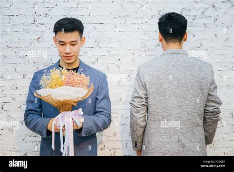 Gay Couple Holding A Bouquet Of Flowers Ready To Give To His Partner For Special Occasions Or