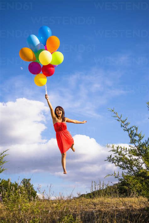 Usa Texas Young Woman Flying With Balloons Stock Photo