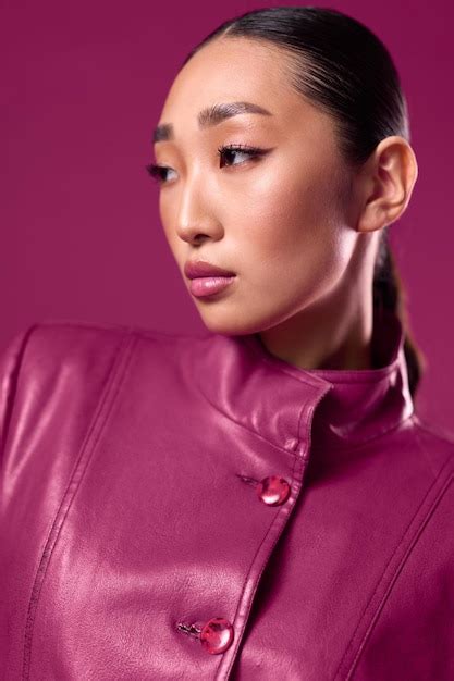 Premium Photo Fashionable Asian Brunette In A Purple Leather Jacket Posing With Her Hair In A