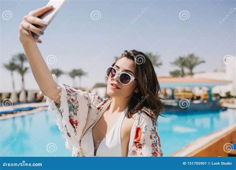 Fille Stupéfiante De Brune Dans Le Bikini Et La Chemise à La Mode Faisant Le Selfie à La Piscine