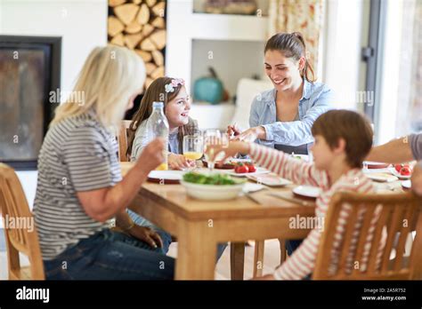 Mother With Children And Grandma Having Lunch Or Dinner At The Dining