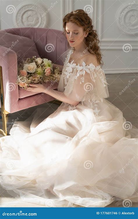 Beautiful Natural Redhead Girl Bride With Nude Makeup Wearing A White Dress Holds A Wedding