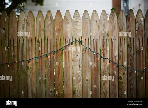 Wooden garden fence with fairy lights Stock Photo - Alamy