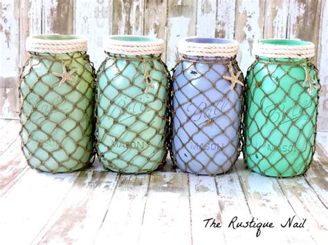 Four Mason Jars Are Lined Up On A Wooden Surface With Rope Wrapped