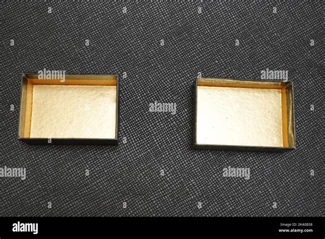 Two Hollow Black And Yellow Jewelry Boxes On A Textured Black