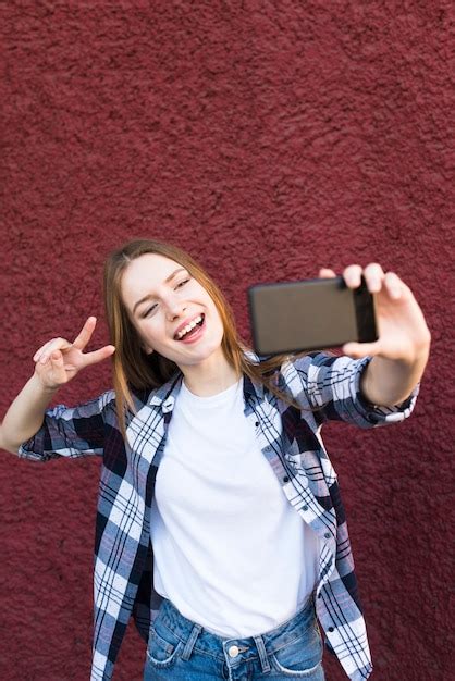 Femme élégante Prenant Selfie Avec Geste De Signe De Paix Photo Gratuite