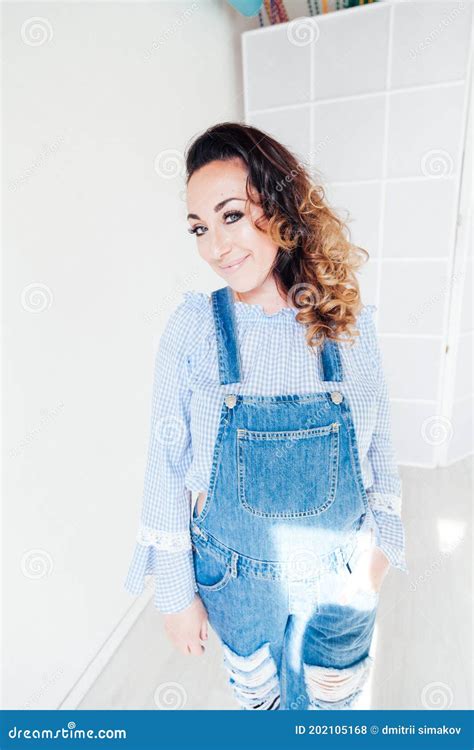 Portrait Of A Beautiful Blonde Woman In A Denim Jumpsuit Stock Photo Image Of Glad Model