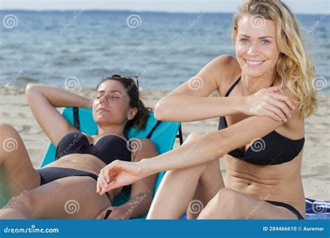 Guapa Rubia En Bikini Aplicando Crema De Sol En La Playa Foto De Archivo Imagen De Sentada