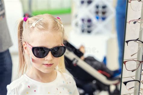 Petite Jeune Fille Blonde Caucasienne Mignonne Essayant Et Choisissant Des Lunettes De Soleil