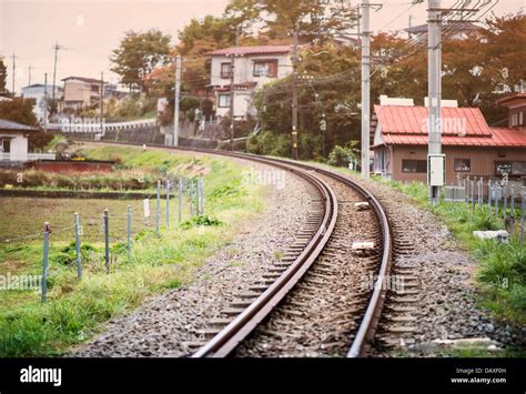 Train tracks run through a rural Japanese neighborhood in Fujiyoshida