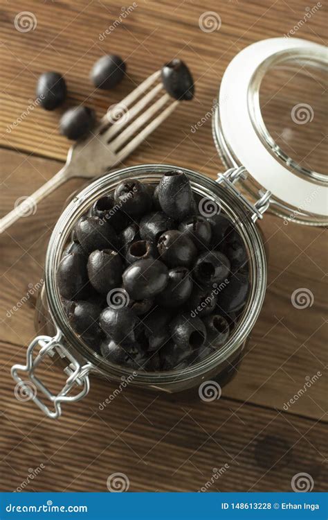Black Olives Pickled Olives In Jar On Wooden Background Stock Photo