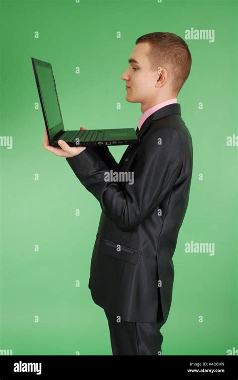 Full Length Portrait Of Confident Mature Businessman Which Working On Laptop In Formals Standing