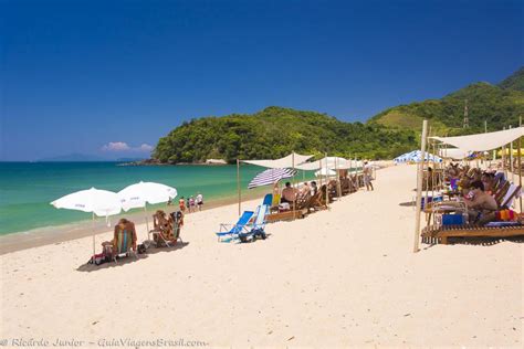 Imagem De Turistas Nas Areias Em Baixo Do Guarda Sol Se Protegendo