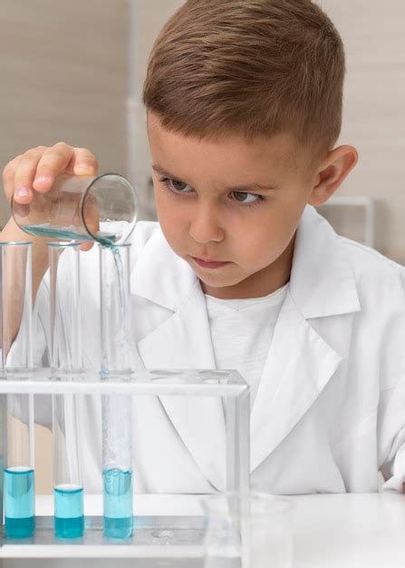 Experimento Científico Para Escola - Garotinho fazendo um experimento científico na escola | Foto Grátis