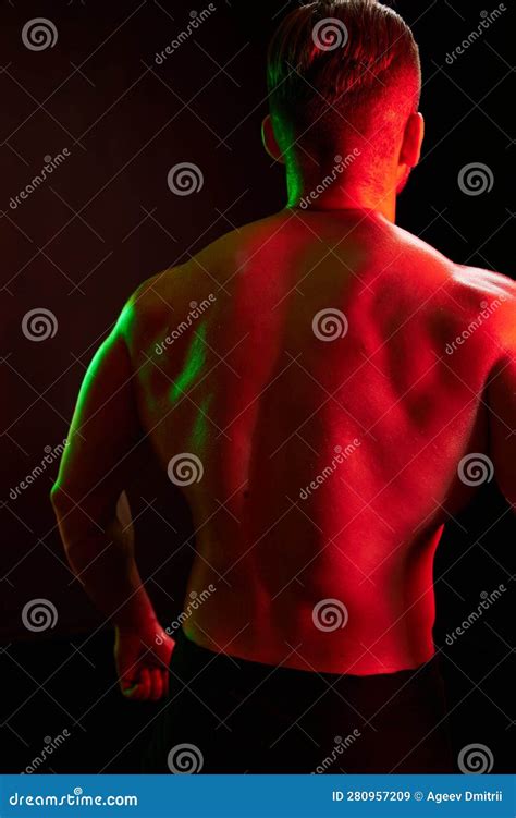 Man Bodybuilder Athlete With Naked Torso In Sports Uniform Isolated On Black Background In Neon