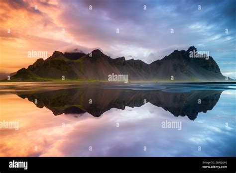 ICELAND, VESTRAHORN, VESTRAHORN MOUNTAIN AT SUNRISE WITH ITS REFLECTION ...